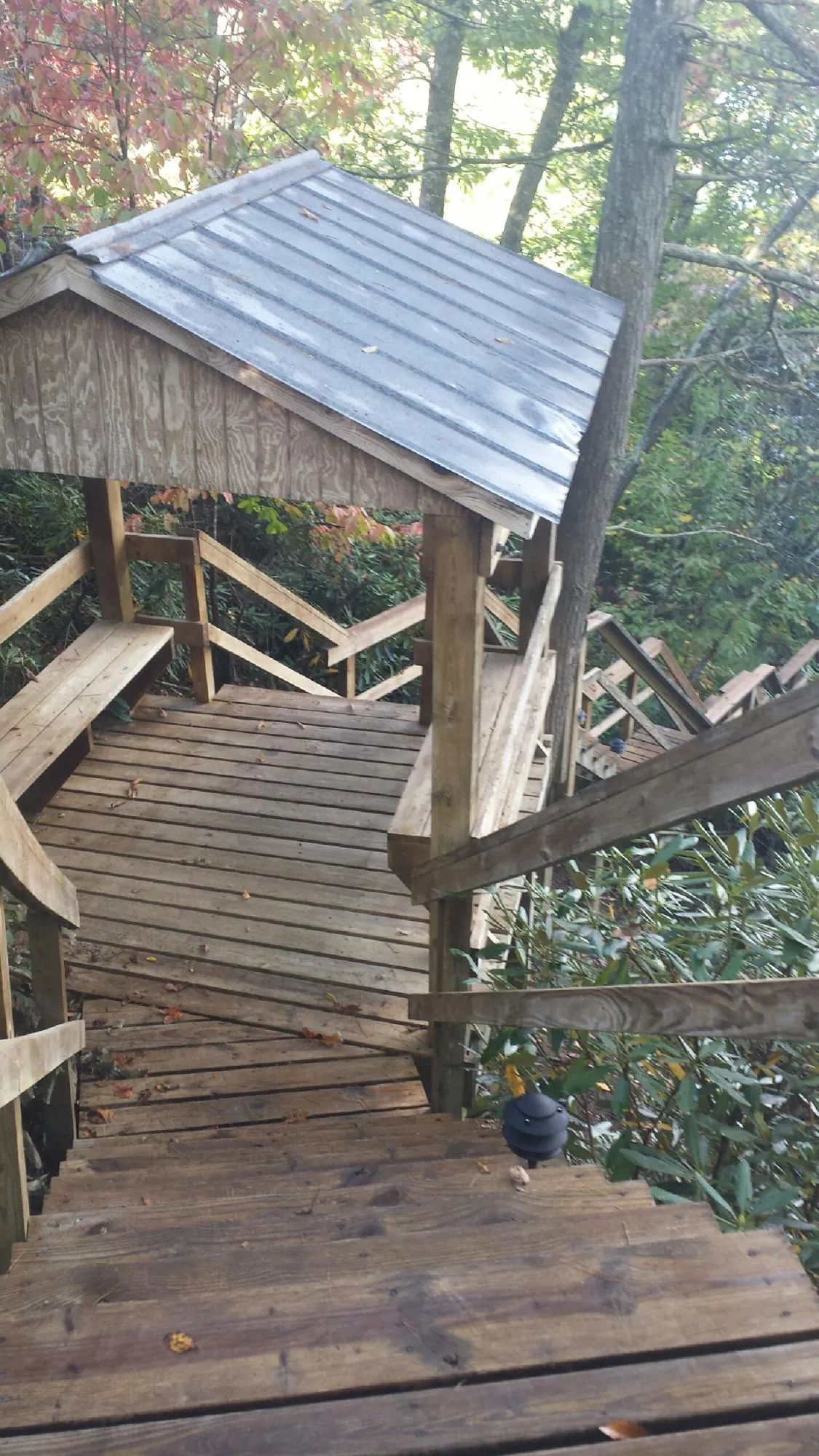 Metal roofed shelter over wooden steps on a wooded walkway — Skylight Repair & Installation work by our crew in Lee Center